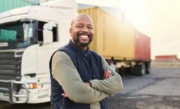 Delivery, container, and smiling truck driver moving industry cargo and freight at shipping supply chain or warehouse